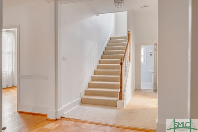 staircase with baseboards and wood finished floors