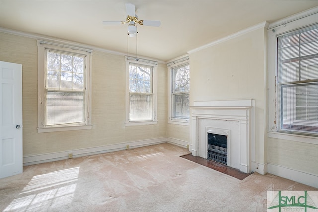 unfurnished living room with baseboards, a fireplace with flush hearth, carpet flooring, and crown molding