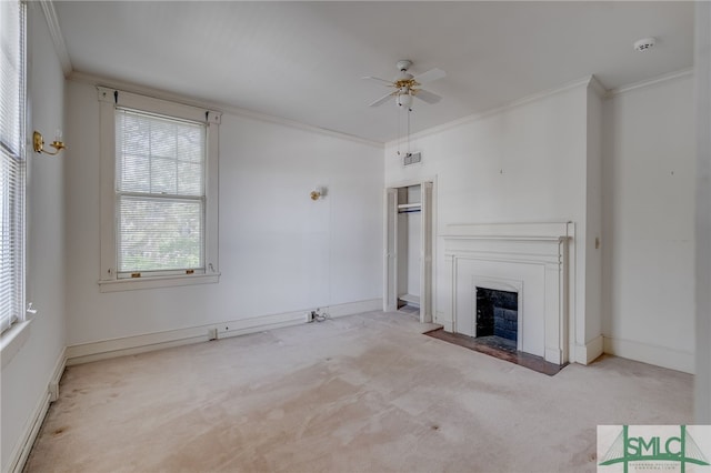 unfurnished living room featuring a ceiling fan, baseboards, a fireplace with flush hearth, ornamental molding, and carpet flooring