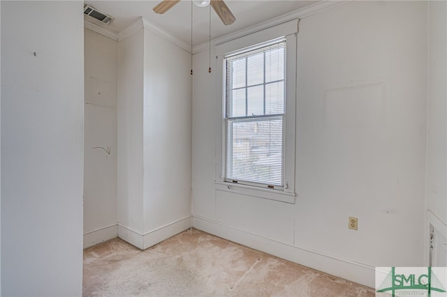 spare room with light carpet, visible vents, ceiling fan, and ornamental molding