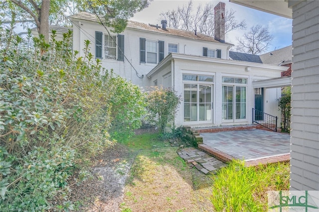 rear view of house with brick siding and a patio area