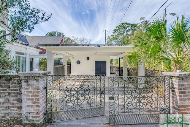 bungalow-style house with a porch, a gate, and a fenced front yard