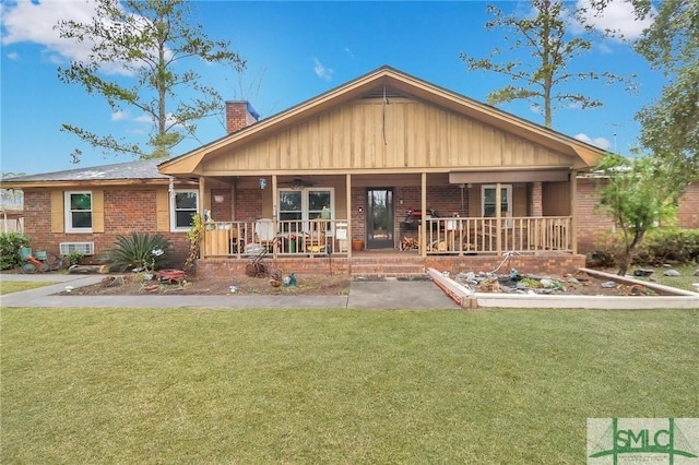 rear view of property featuring a porch and a yard