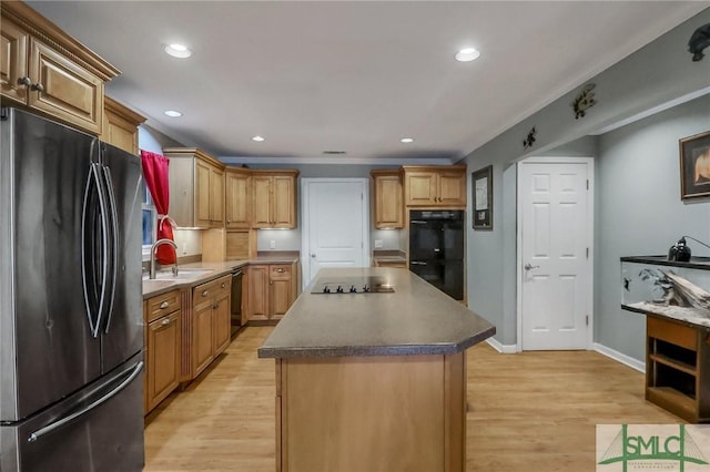 kitchen with a kitchen island, sink, light wood-type flooring, and black appliances