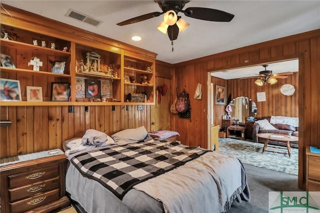 bedroom with carpet floors and wooden walls