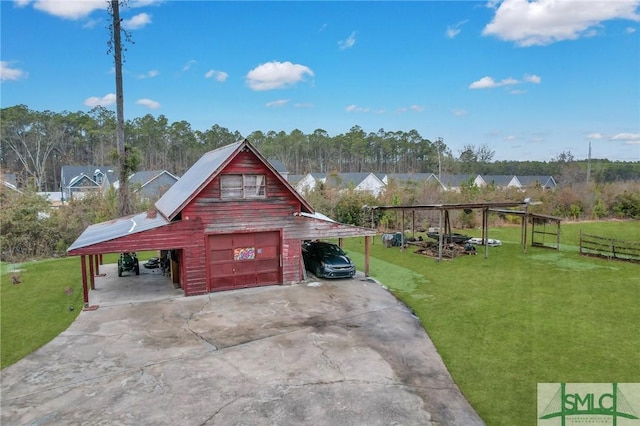 exterior space featuring a garage, an outdoor structure, and a front lawn