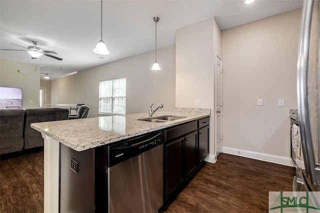 kitchen featuring dark wood-type flooring, sink, kitchen peninsula, pendant lighting, and stainless steel appliances