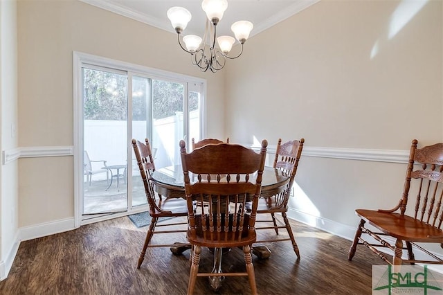 dining room featuring ornamental molding, dark hardwood / wood-style floors, and an inviting chandelier