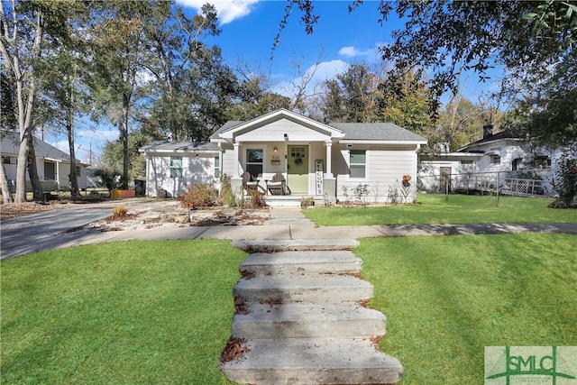 bungalow with a front lawn and covered porch