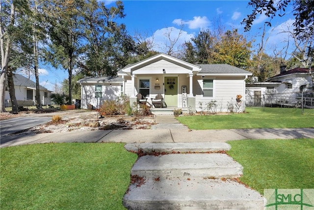 bungalow with a front yard and covered porch