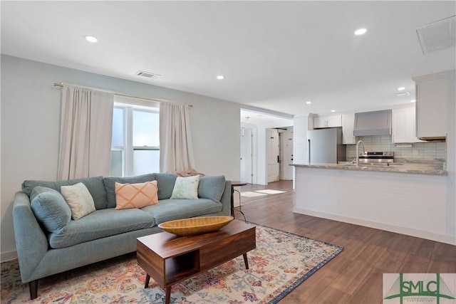 living room with hardwood / wood-style flooring and sink