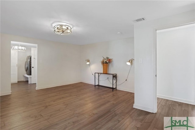 unfurnished room with dark wood-type flooring and washer / clothes dryer