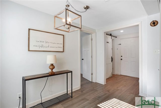 hall with hardwood / wood-style flooring and a barn door