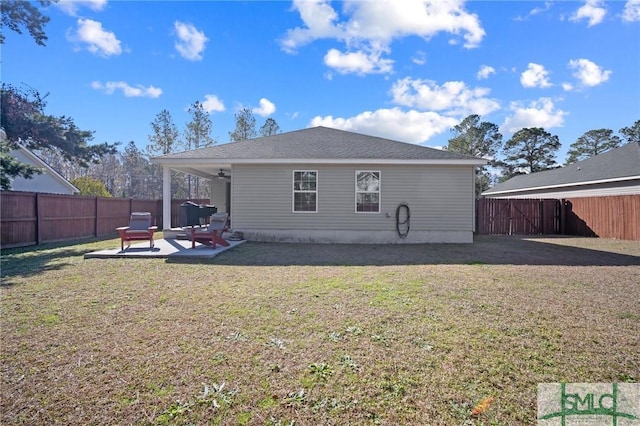 back of property with a yard and a patio