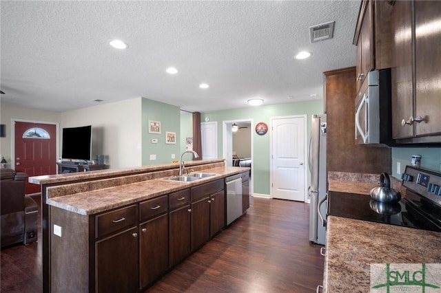 kitchen featuring appliances with stainless steel finishes, an island with sink, sink, and dark brown cabinets