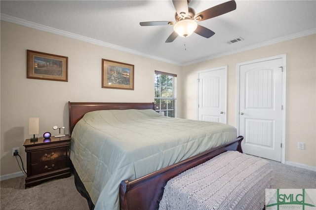 bedroom with crown molding, ceiling fan, carpet floors, and two closets