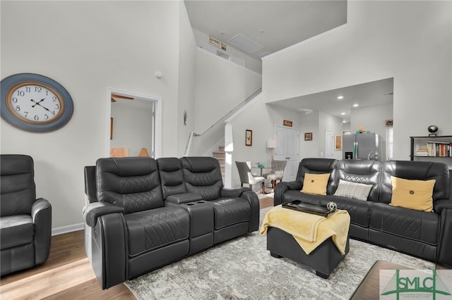 living room with a towering ceiling and hardwood / wood-style floors