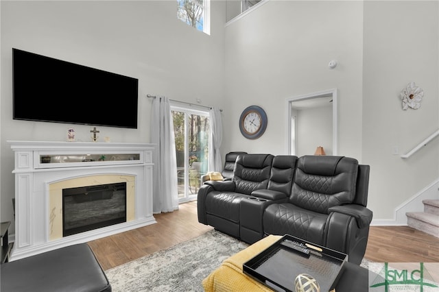 living room with hardwood / wood-style flooring and a towering ceiling