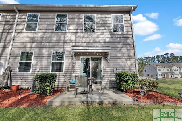 back of house featuring a patio and a yard