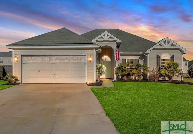 single story home featuring a garage and a lawn