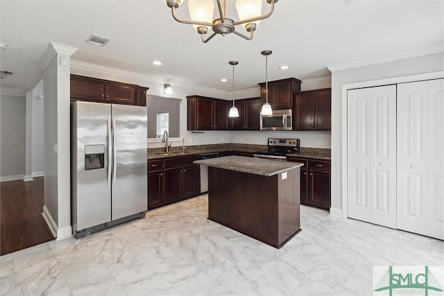 kitchen featuring appliances with stainless steel finishes, sink, dark stone counters, hanging light fixtures, and a center island