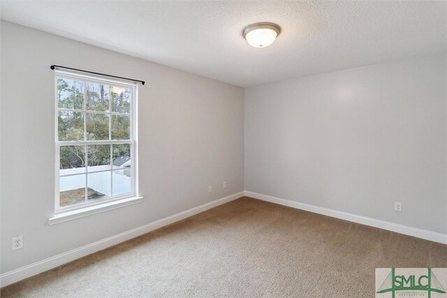 carpeted empty room with a textured ceiling