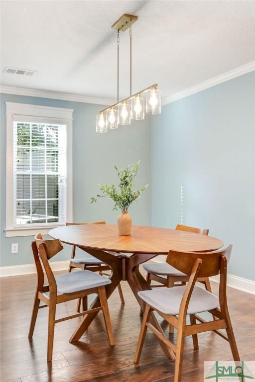 dining space with hardwood / wood-style floors and crown molding