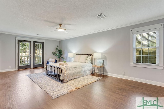 bedroom with crown molding, wood-type flooring, access to exterior, and a textured ceiling