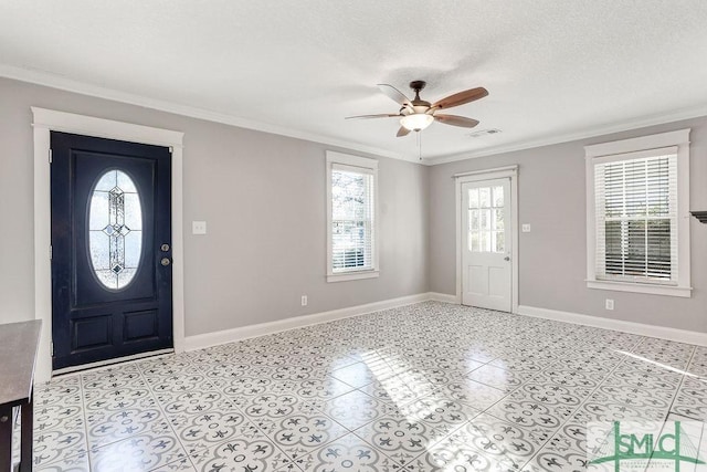 tiled foyer entrance with crown molding, a textured ceiling, and ceiling fan