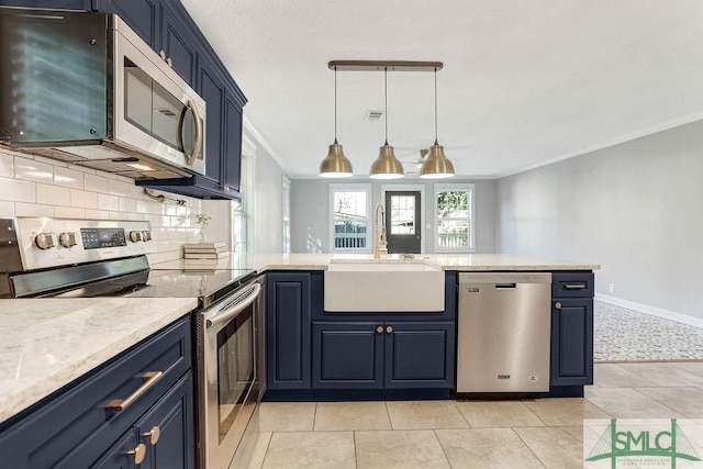 kitchen with blue cabinetry, appliances with stainless steel finishes, sink, and hanging light fixtures