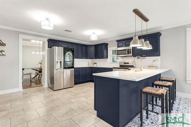 kitchen with a breakfast bar, blue cabinetry, kitchen peninsula, and appliances with stainless steel finishes