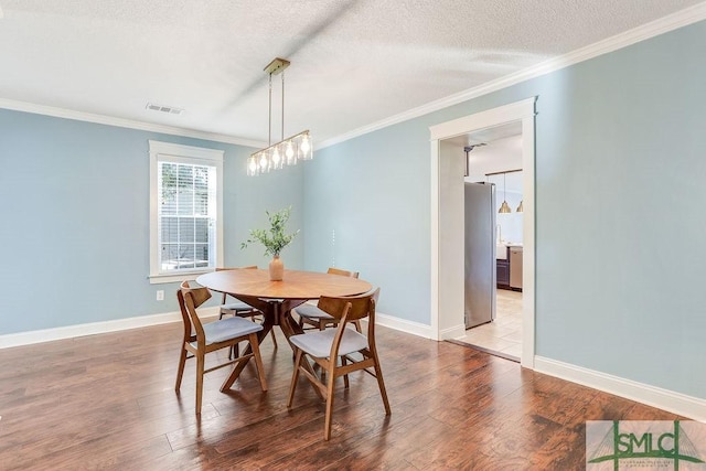 dining area with crown molding, hardwood / wood-style floors, and a textured ceiling