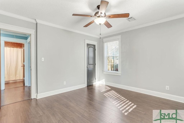 spare room featuring crown molding, dark wood-type flooring, and ceiling fan