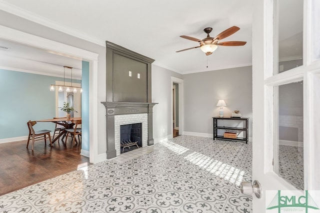 living room with ornamental molding, ceiling fan with notable chandelier, light tile patterned flooring, and a fireplace