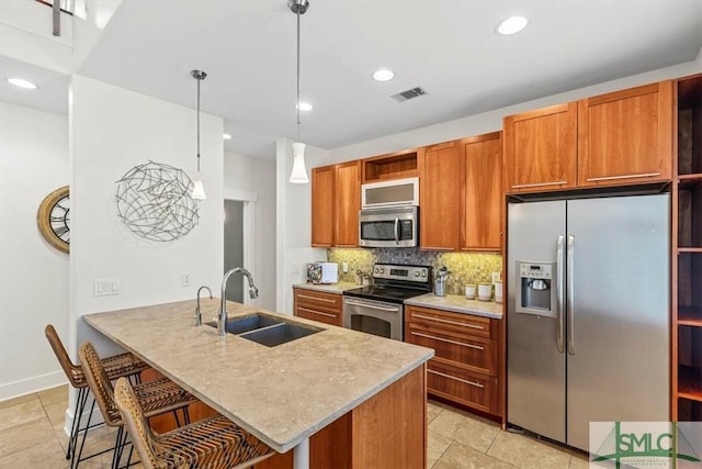 kitchen featuring pendant lighting, sink, a breakfast bar area, stainless steel appliances, and kitchen peninsula