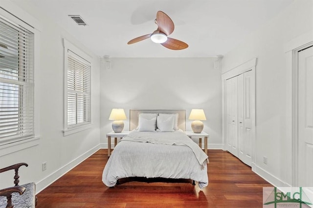 bedroom with dark hardwood / wood-style floors and ceiling fan