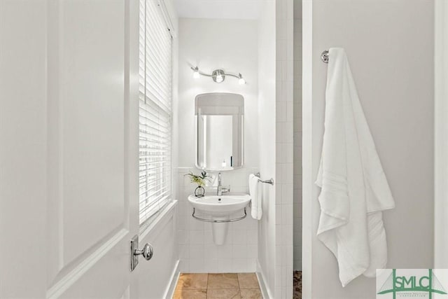 bathroom with tile patterned flooring and tile walls