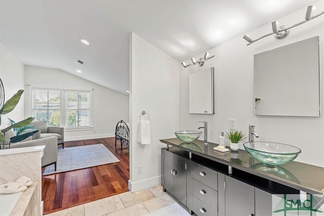 bathroom with tile patterned floors, lofted ceiling, and vanity