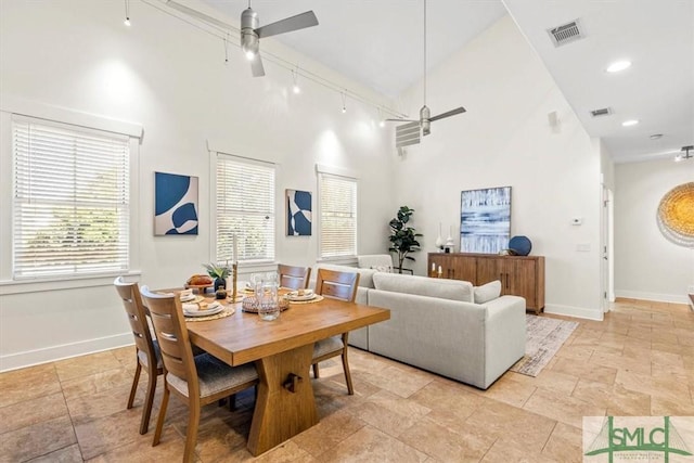 living room featuring a high ceiling, rail lighting, and ceiling fan