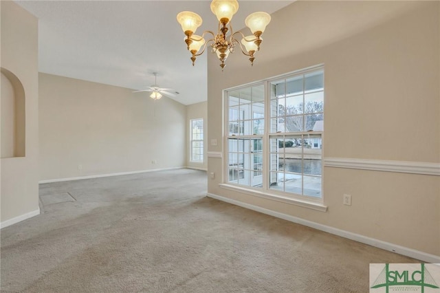 carpeted spare room featuring lofted ceiling and ceiling fan with notable chandelier