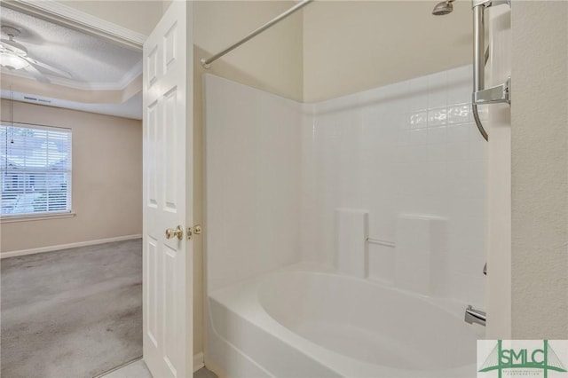 bathroom with ceiling fan, ornamental molding,  shower combination, and a textured ceiling