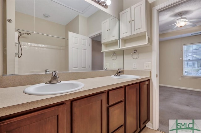 bathroom featuring ceiling fan, vanity, and a shower