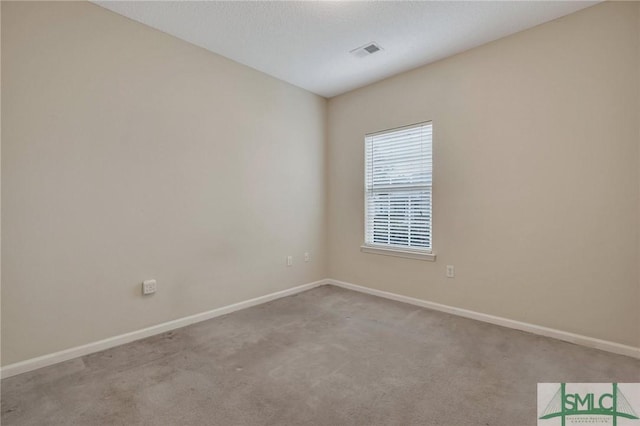 spare room with light colored carpet and a textured ceiling