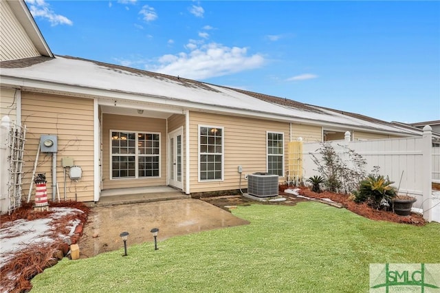 rear view of property featuring cooling unit, a lawn, and a patio