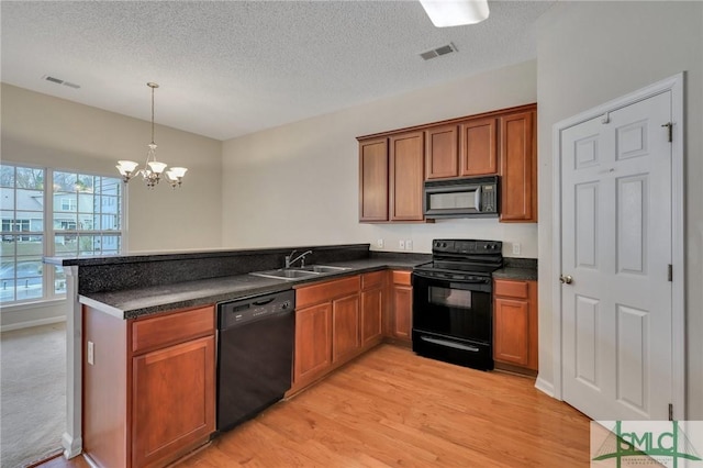 kitchen featuring sink, kitchen peninsula, pendant lighting, light hardwood / wood-style floors, and black appliances