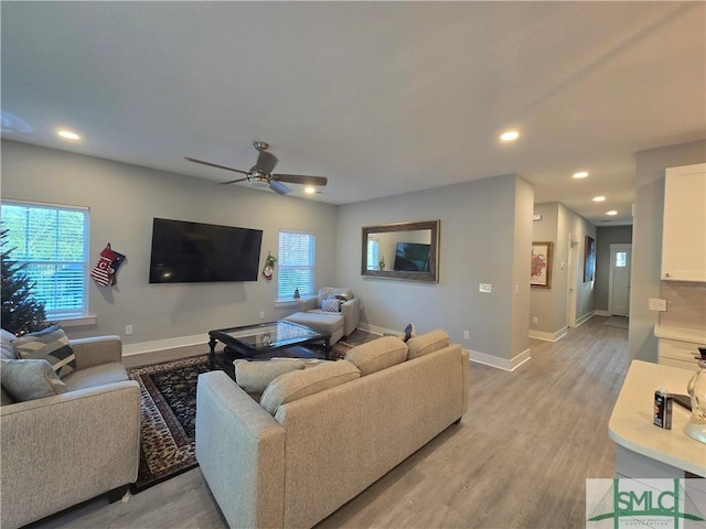 living room featuring light hardwood / wood-style floors and ceiling fan