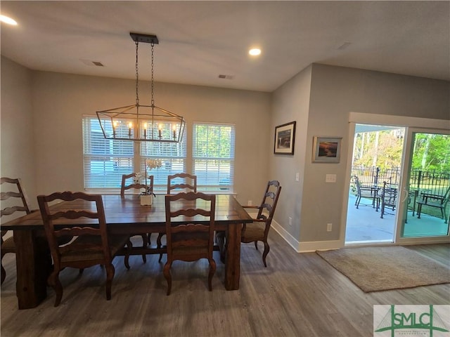 dining room featuring a notable chandelier, a wealth of natural light, and wood-type flooring