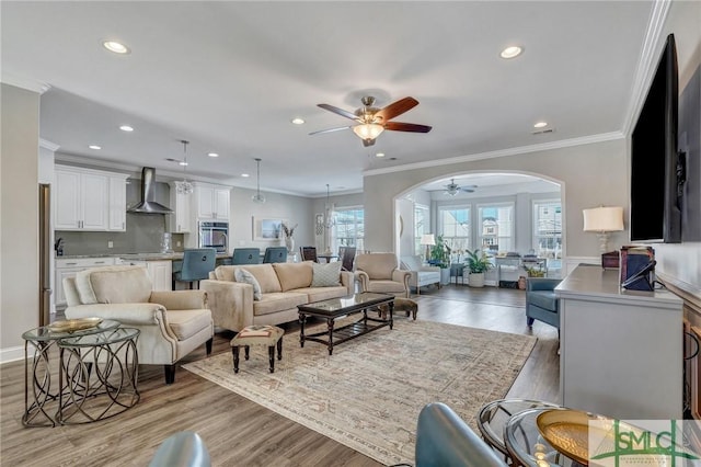 living room featuring crown molding, ceiling fan, and light hardwood / wood-style floors