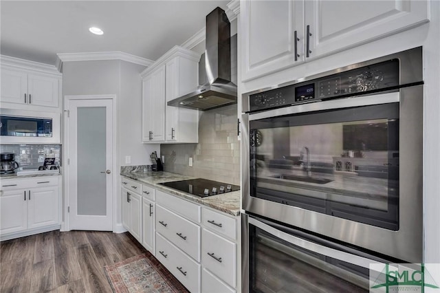 kitchen featuring black electric cooktop, white cabinets, light stone countertops, and wall chimney range hood