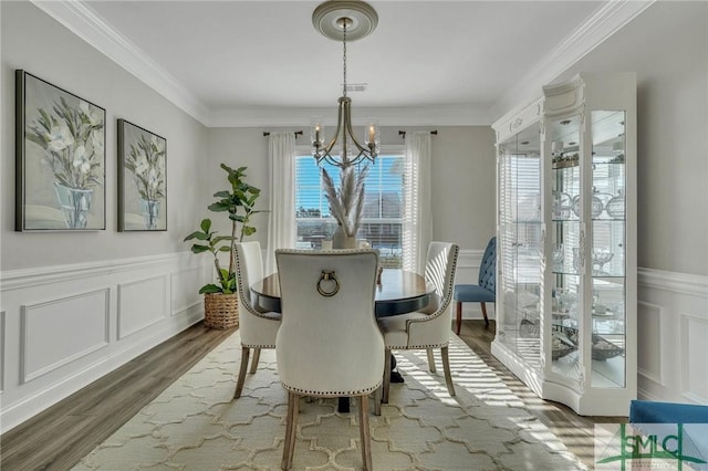 dining space with ornamental molding, dark hardwood / wood-style floors, and a notable chandelier